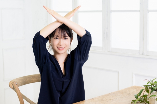 お見舞いのお返しにダメなものを示して手でバツをつくる女性